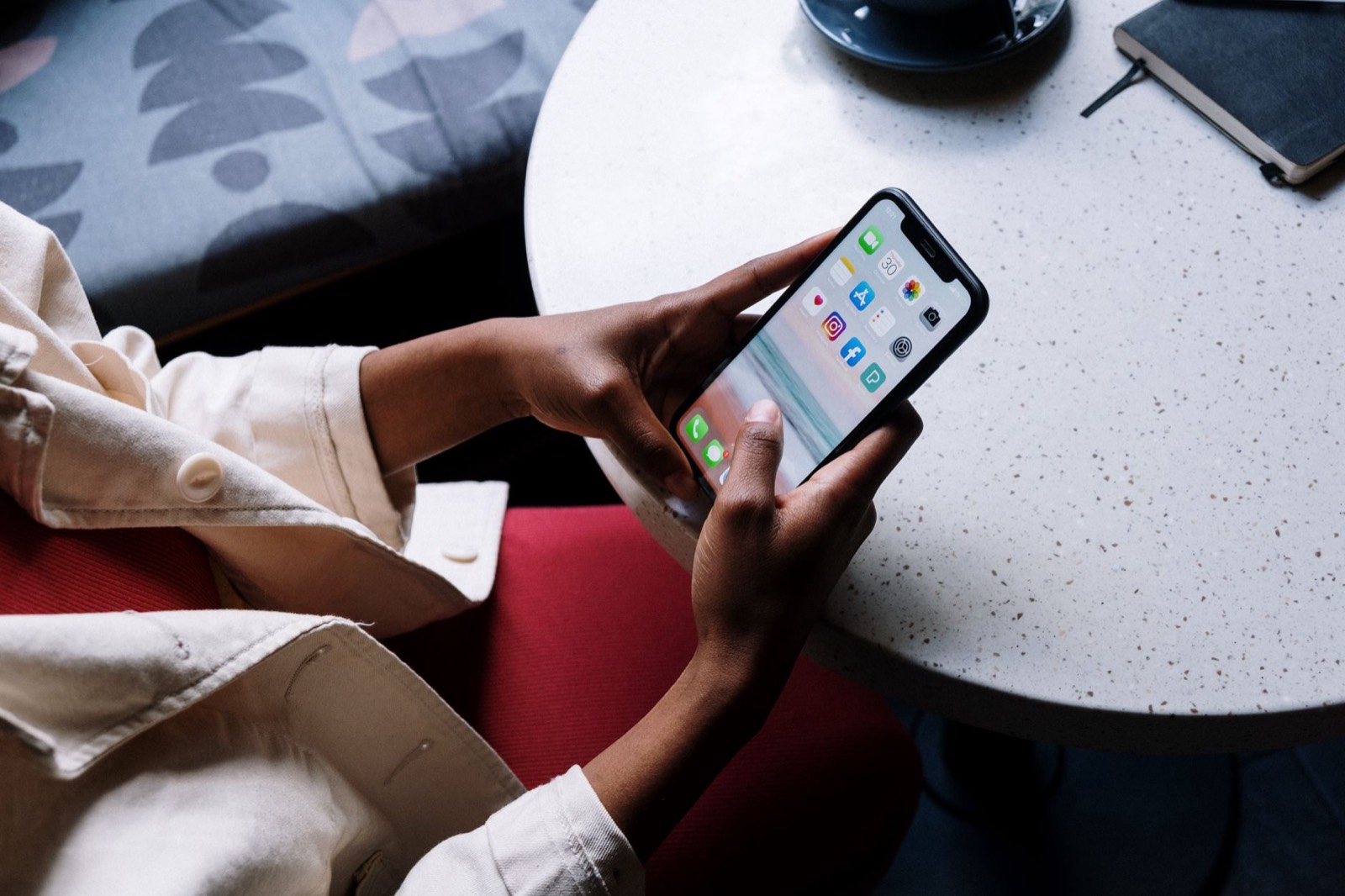 Main tenant un smartphone posé sur une table de café, avant un premier rendez-vous