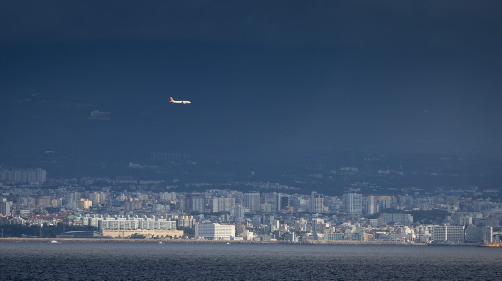 Petit avion tractant une banderole publicitaire au-dessus d'une côte