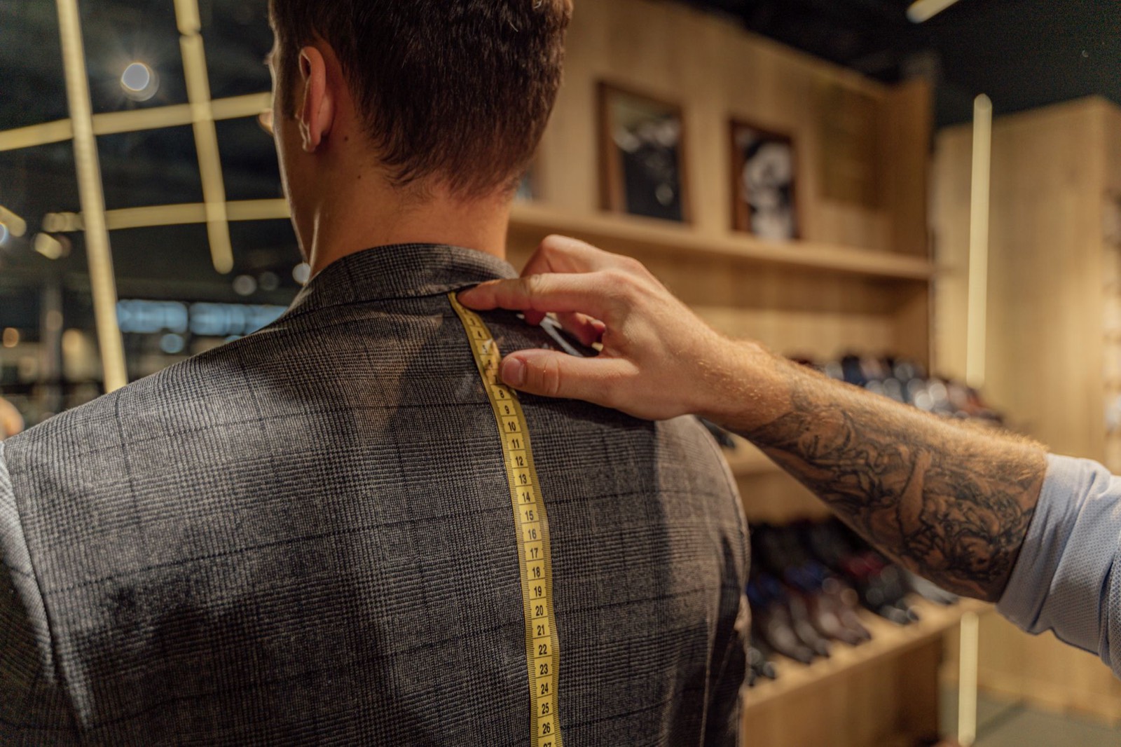 Prise de mesure des épaules d'une veste homme chez un tailleur