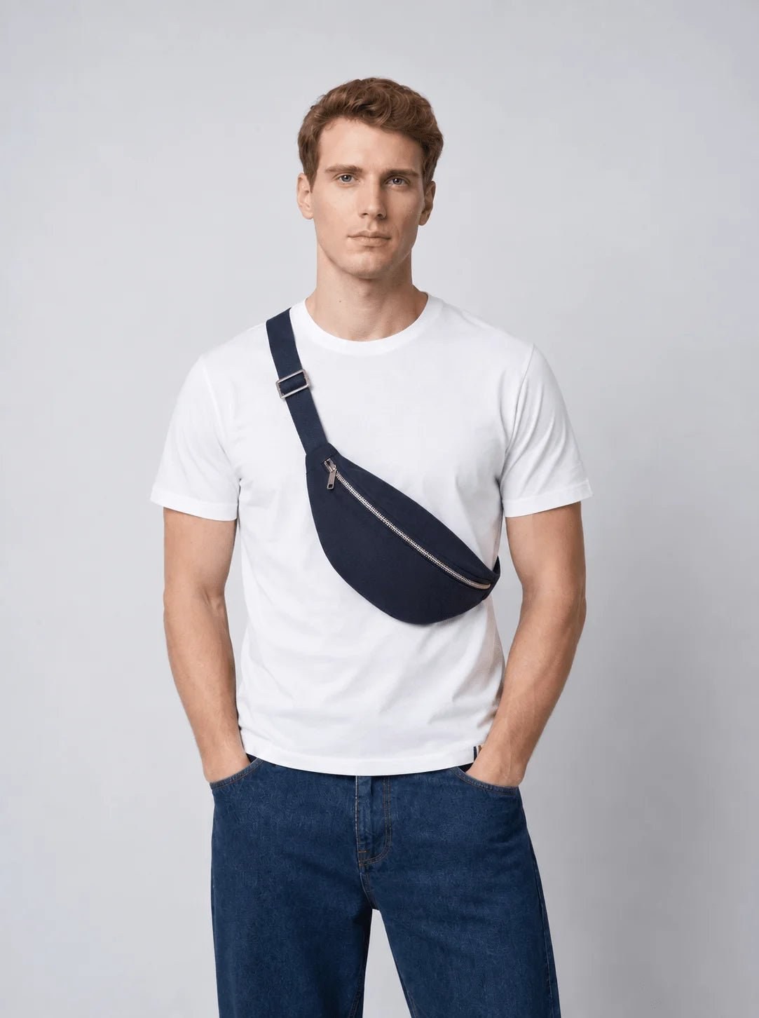 Homme en T-shirt blanc portant le sac banane L'Essentiel bleu marine en bandoulière